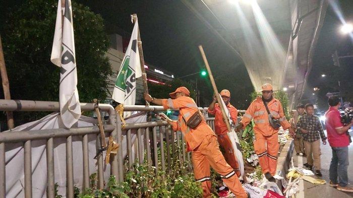 Sejumlah petugas PPSU hingga Satpol PP Jakarta Selatan mulai melakukan pencopotan Alat Peraga Kampanye (APK) sekira pukul 00.30 WIB. di Jalan Kapten Tendean, Mampang Prapatan, Jakarta Selatan, Minggu (11/2/2024). Terhitung tanggal 11-13 Februari 2024 adalah masa tenang sebelum kemudian pencoblosan pada 14 Februari 2024.