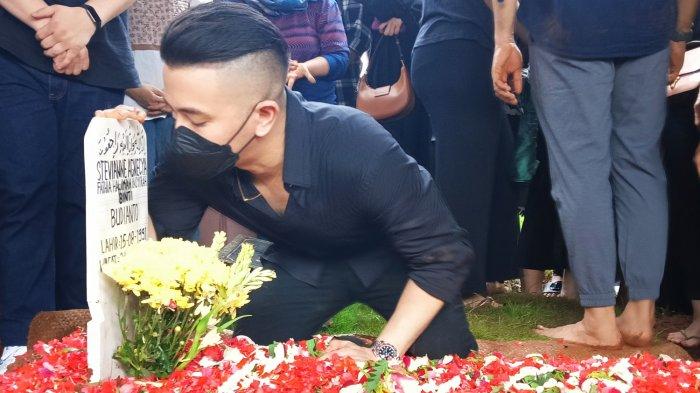 ggi Pratama, suami Stevie Agnecia saat mencium nisan istrinya usai pemakaman di TPU Tanah Kusir, Jakarta Selatan, Jumat (22/3/2024) siang.