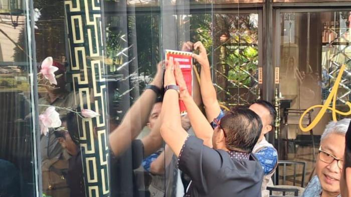 HOTEL TUNGGAK PAJAK - Proses Pemkot Bekasi memasang stiker tidak patuh pajak di sebuah hotel mewah di kawasan Kecamatan Bekasi Selatan. Kepala Bidang Pengawasan dan Pengendalian Pajak Badan Pendapatan Daerah (Bapenda) Kota Bekasi, Robbie Arfiansyah membenarkan kalau hotel tersebut kesulitan membayar pajak lantaran omzet menurun imbas kebijakan efisiensi anggaran pemerintah. (Dok Bapenda).
