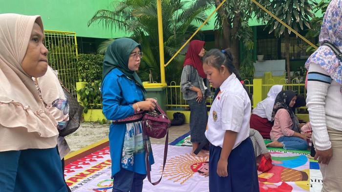 PENYINTAS DOWN SYNDROM - Sri Endang Wahyuni (54) dan putrinya Kayla Dwi Pramesty (15), penyintas Downsyndrom dan kelainan jantung pada momen hari pertama MPLS di SLBN 5 Jakarta, Senin (14/7/2025).