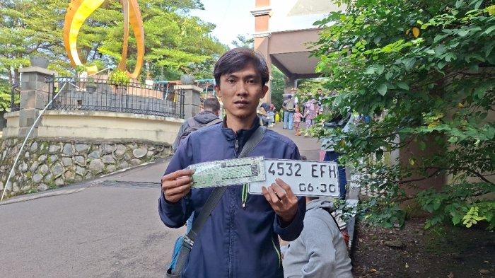 PEMUTIHAN PAJAK - Wahyu Romadhona menunjukkan plat motor dan STNK baru usai mengurus pemutihan pajak kendaraan di Kantor Samsat Depok, Rabu (25/6/2025). Meski sudah 13 tahun menunggak pajak, dirinya hanya membayar pajak sepeda motornya sebesar Rp 290.000. 