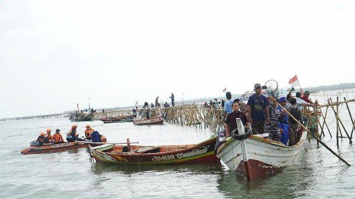 Ratusan nelayan turut serta membongkar pagar bambu kompak terjun ke laut di Ketapang Pelelangan, Mauk, Kabupaten Tangerang, Rabu (22/1/2025). Kompaknya para nelayan itu, didasari atas rasa syukur, lantaran pagar laut yang sebelumnya menghambat mereka melaut, kini telah dihancurkan. Bambu yang telah dicopot itu pun kemudian diangkat satu persatu ke kapal para nelayan. Warta Kota/Yulianto