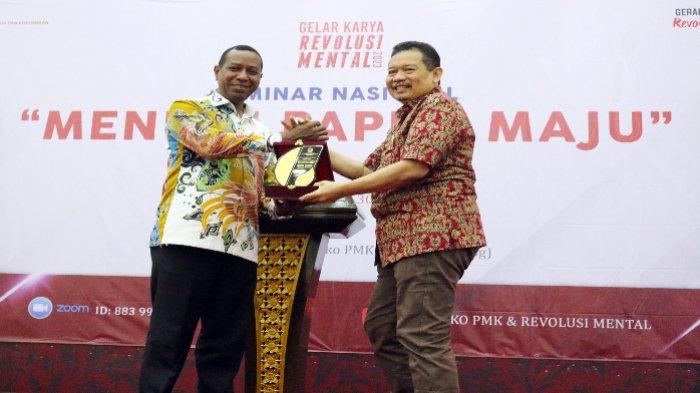 Deputi Bidang Koordinasi Revolusi Mental, Pemajuan Budaya, dan Peningkatan Prestasi Olahraga Kemenko PMK Didik Suhardi (kanan) memberikan plakat kepada Pj Gubernur Papua Selatan Apolo Safanpo (kiri) dalam acara seminar nasional dengan tema 