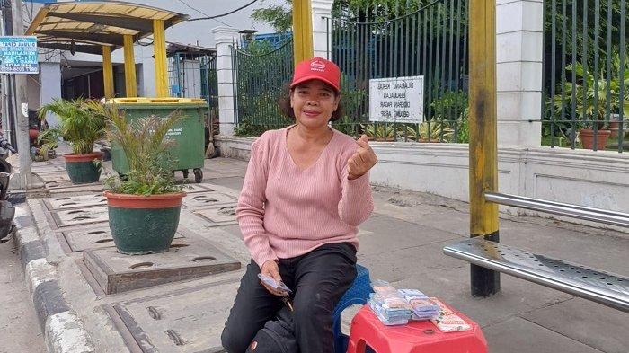 Shelmi (58) di sela menjajakan uang tukar pecahan Rp2.000 hingga Rp50.000, di sepanjang Jalan Gajah Mada, Tamansari, Jakarta Barat