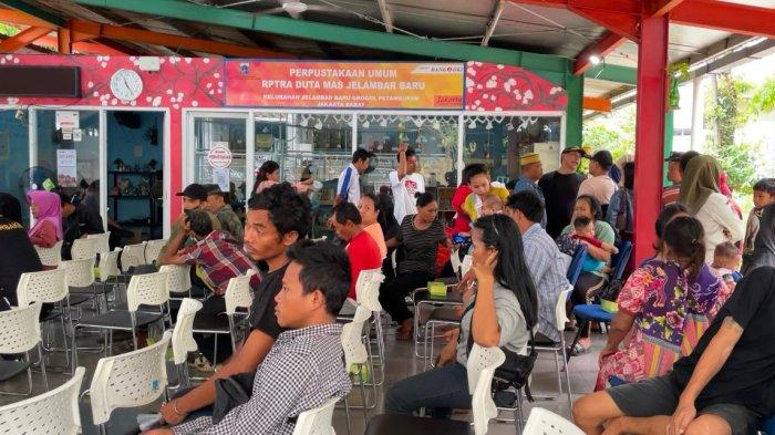 Suasana penyaluran kompensasi bagi warga Kampung Kolong Tol Angke di Kecamatan Grogol Petamburan Jakarta barat pada Rabu (4/12/2024). Warga KTP non DKI Jakarta diberikan kompensasi berupa uang Rp 1,5 juta dan sembako.