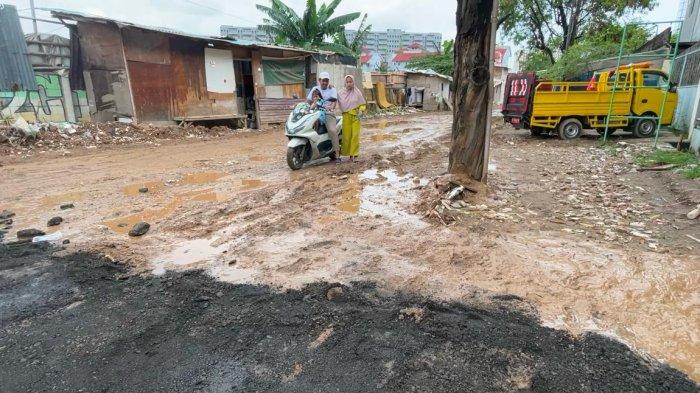 Suasana perbaikan jalan berlumpur di depan SMK Cengkareng 2, Jakarta Barat pada Selasa (21/1/2025). 