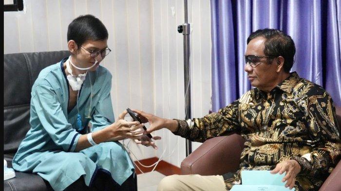 Menteri Koordinator Bidang Politik, Hukum, dan Keamanan Indonesia (Polhukam), Mohammad Mahfud Mahmodin atau Mahfud MD menjenguk Sultan Rif'at Alfatih (20), mahasiswa korban terjerat kabel optik di Jalan Pangeran Antasari, Kebayoran Baru, Jakarta Selatan yang dirawat di RS Polri, Kramat Jati, Jakarta Timur, Jumat (4/8/2023) sekira pukul 18.35 WIB. Sultan berkomunikasi dengan Mahfud lewat ketikan jari di HP nya.