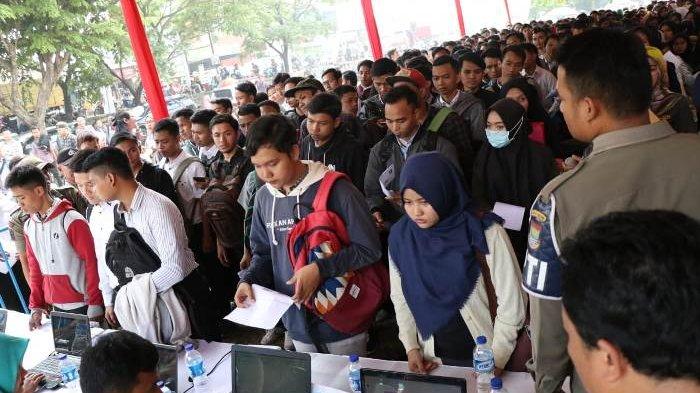 Para pencari kerja sedang mengantre mendaftarkan diri mereka di acara Job Fair.