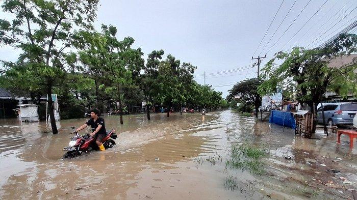 Warga di perumahan Nirwana Residence, Karang Bahagia, Cikarang, Kabupaten Bekasi, terpaksa menerobos banjir, Minggu (7/7/2024). Sebab sejak Sabtu (6/7/2024) sore banjir tak kunjung surut, akibat hujan deras yang terjadi di Jabodetabek.