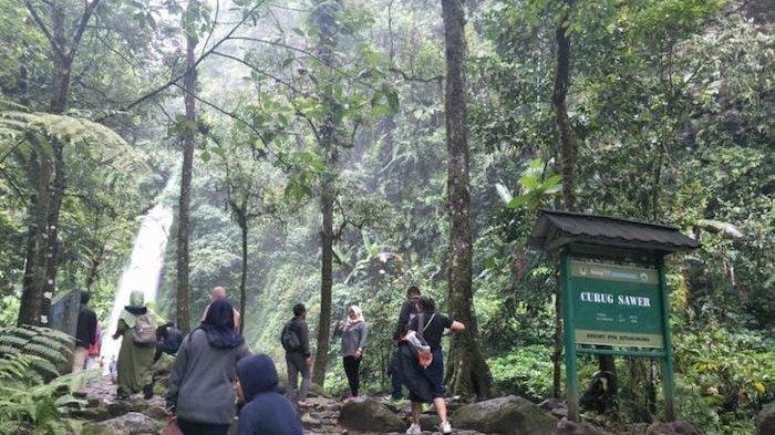 Pengunjung berfoto di dekat Curug Sawer yang terletak di dalam kawasan wisata Situ Gunung, Sukabumi, Jawa Barat.