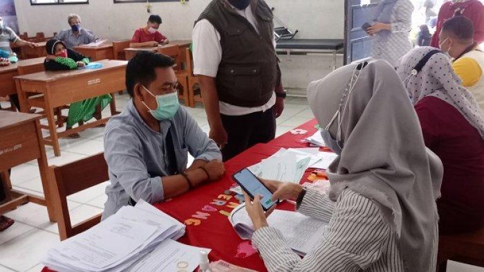Ilustrasi penerimaan Bansos. Keterangan foto: warga Kota Tangerang sedang menerima dana bantuan sosial dari pemerintah Rp 300.000 per keluarga penerima manfaat, di SMPN 7 Kota Tangerang, Rabu (25/8/2021).