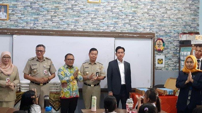 Wakil Presiden RI Gibran Rakabuming Raka didampingi Penjabat Gubernur DKI Teguh Setyabudi sedang menyaksikan anak kelas 2 SDN 03 Menteng, Jakpus, menyantap nasi kotak dari program makan bergizi gratis, Selasa (22/10/2024).