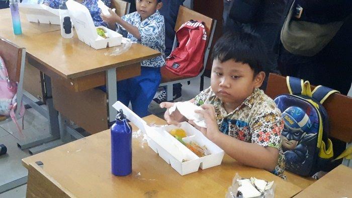 Siswa SDN 07 sedang menyantap makan bergizi gratis dari Pemprov DKI, Jumat (20/9/2024).