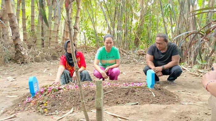 Busia (tengah), ibu atlet binaraga Justyn Vicky saat mengunjungi makam anaknya yang meninggal dunai akibat patah leher saat latihan. Justyn dimakamkan di Desa Ajung, Kecamatan Kalisat, Kabupaten Jember, Jawa Timur.