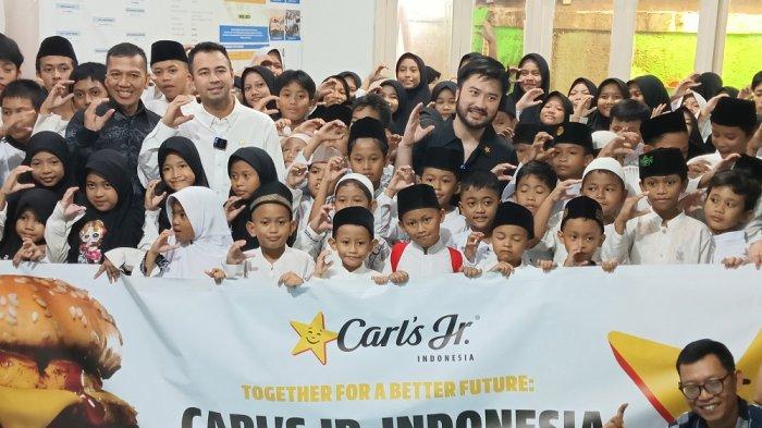 Raffi Ahmad dan Rudy Salim saat berbagi burger di Rumah Yatim Bangka, Kemang, Jakarta Selatan, Jumat (10/1/2025).