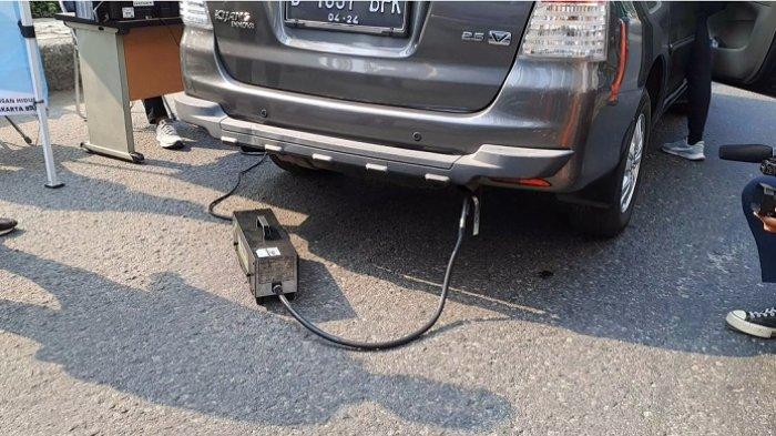 Sebuah mobil pribadi sedang mengikuti uji emisi di Taman Anggrek.