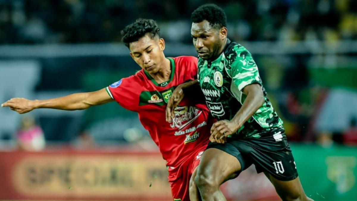 Pemain muda Persebaya Surabaya, Alfan Suaib saat berduel dengan striker PSS Sleman, Ricky Cawor dalam laga pekan perdana Liga 1 2024/2025 di Stadion Gelora Bung Tomo (GBT), Surabaya, Minggu (11/8/2024).