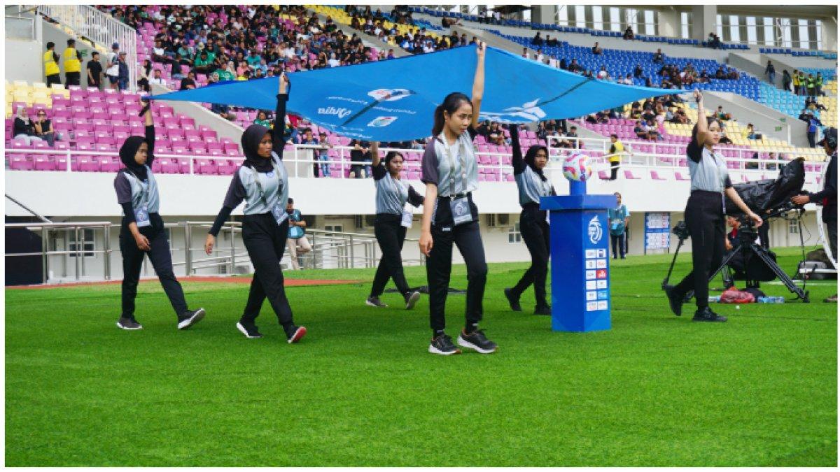 Ball kids perempuan di Stadion Manahan, Solo ketiga membawa giant flag BRI Liga 1 2024-2025.