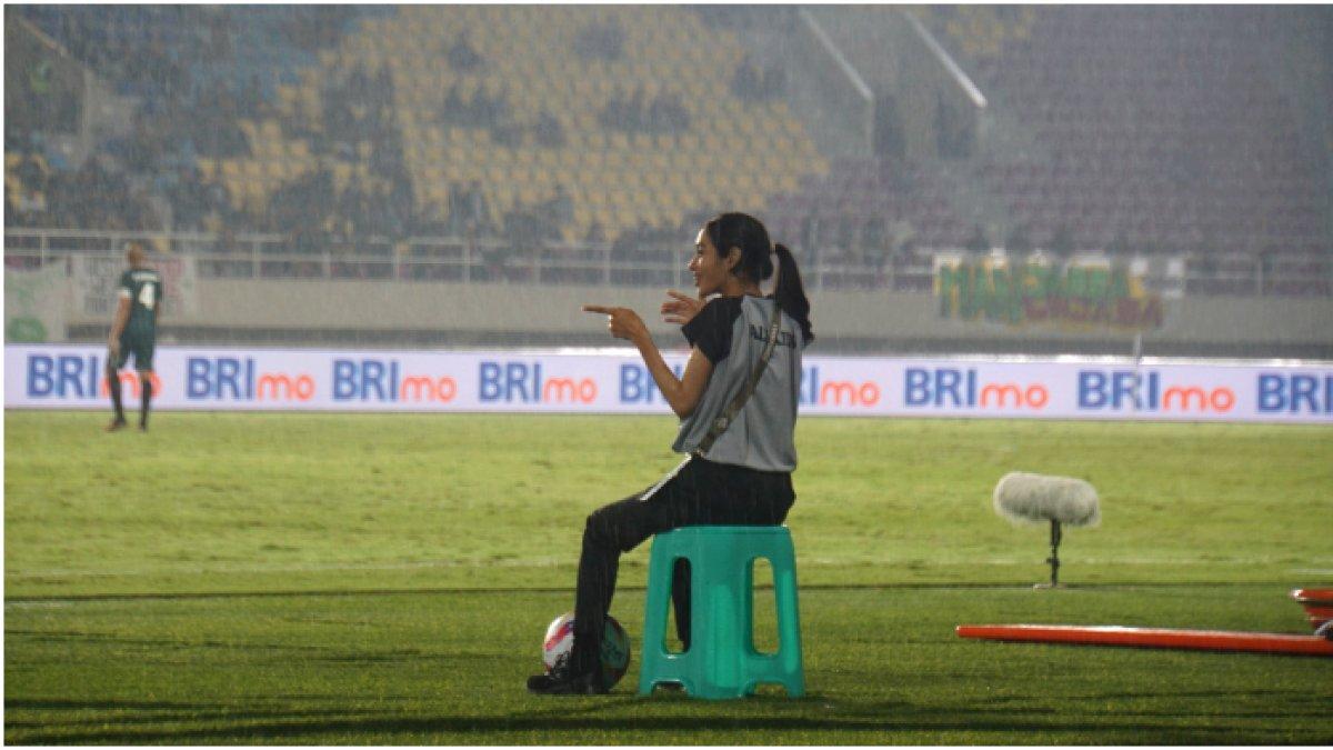 Ball kids perempuan yang bertugas di Stadion Manahan, Solo sedang tertawa sambil kehujanan.