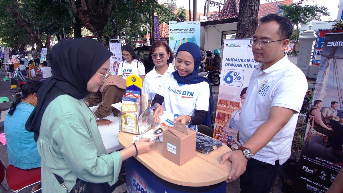 Branch Manager BTN Cabang Solo, Cesar AB sedang mendampingi anak buahnya di stan BTN yang ada di CFD Slamet Riyadi, Surakarta, Jawa Tengah pada Minggu (18/2/2024).