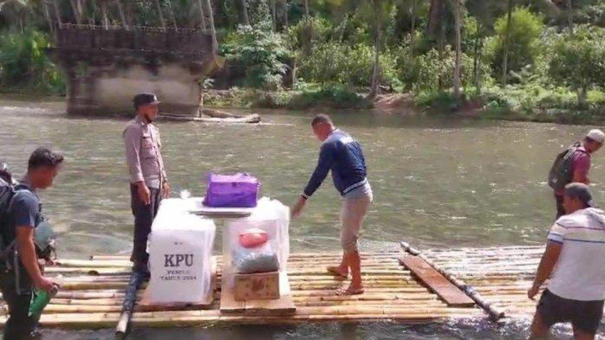 PEMILU: Bripka Firmansyah Alibasa dan 2 penyelenggara Pemilu tingkat desa di Kecamatan Taliabu Utara, terpaksa naik rakit berbayar karena akses jembatan di sungai Samada putus, saat kawal kotak suara.