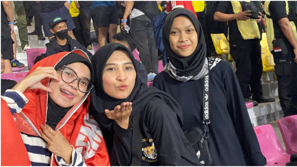 Bunga Pertiwi (kiri) bersama kedua temannya menyaksikan pertandingan Persija Jakarta di stadion.
