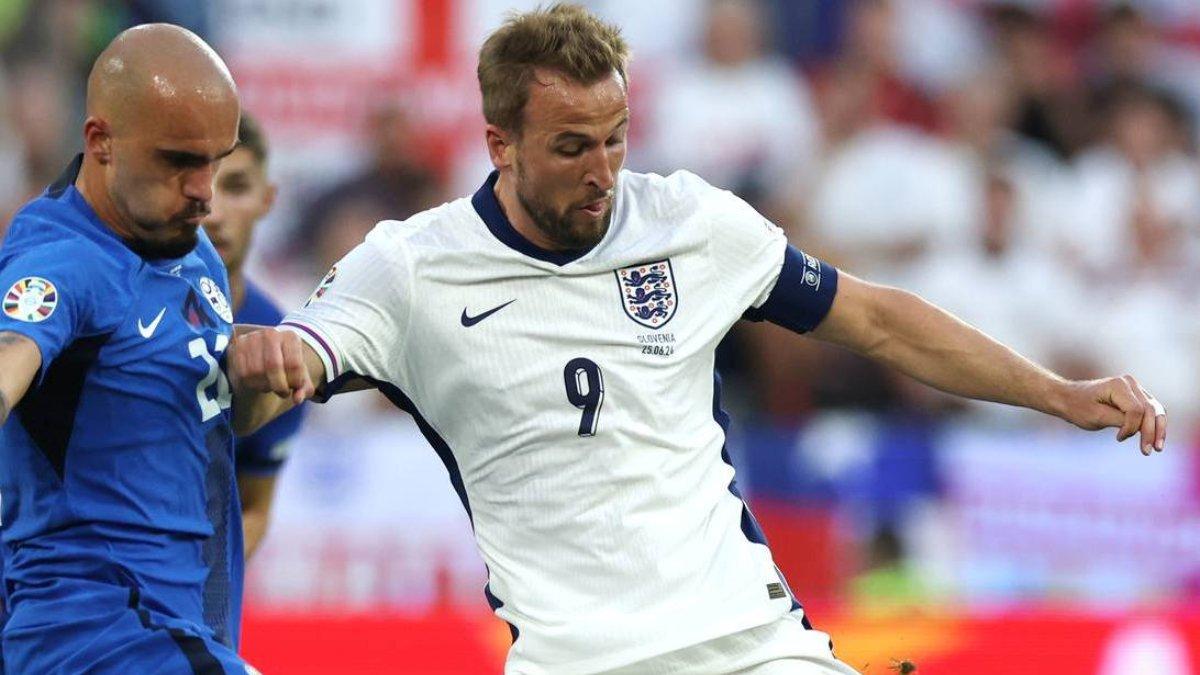 Duel kapten Timnas Inggris Harry Kane (kanan) dengan bek Slovenia, Vanja Drkušić (kiri) di laga pamungkas grup C EURO 2024 di Stadion RheinEnergie, Jerman, Rabu (26/6/2024).