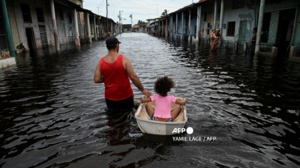 Masyarakat Cuba berjalan menyusuri banjir yang disebabkan oleh Badai Helene pada Kamis (26/9/2024).