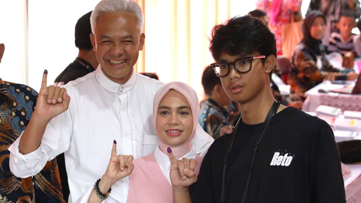 Calon Presiden nomor urut 3 Ganjar Pranowo bersama istrinya Siti Atikoh dan anaknya Muhammad Zinedine Alam Ganjar menunjukkan jari usai menggunakan hak pilihnya di TPS 11, Lempongsari, Gajahmungkur, Semarang, Jawa Tengah, Rabu (14/2/2024).