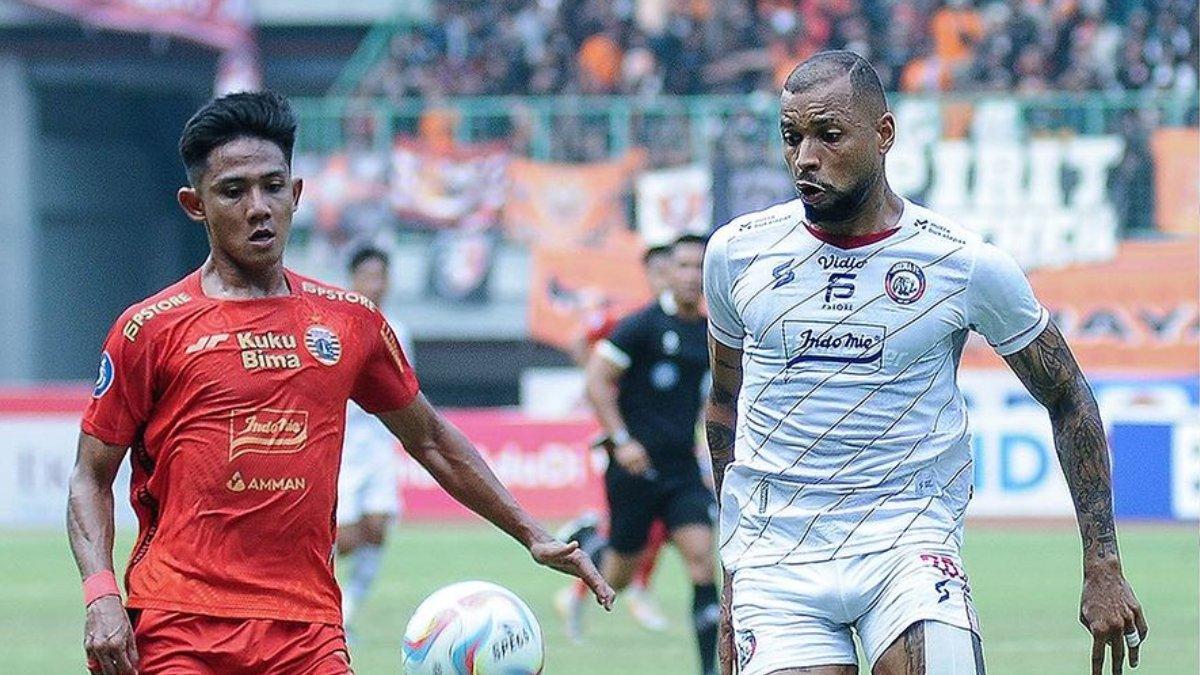 Bomber Arema FC, Gustavo Almeida saat dikawal pemain Persija Jakarta, Firza Andika dalam lanjutan Liga 1 2023 pekan kesembilan di Stadion Patriot Candrabhaga, Bekasi, Minggu (20/8/2023).