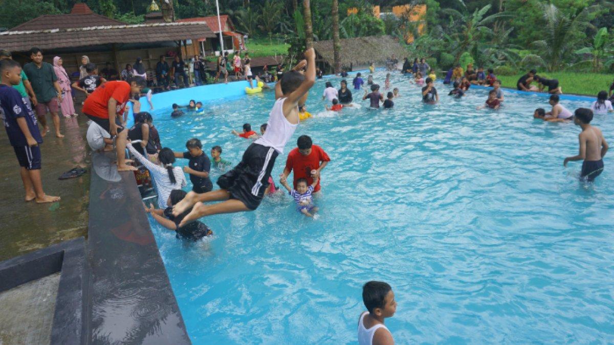 Suasana kolam renang di Arenan Kalikesek yang ramai pengunjung, pada Selasa (2/4/2025).