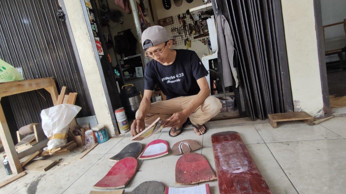 Pemilik Loosewood, Andhika Praditya (31) saat memilih limbah kayu bekas papan skateboard untuk diolah menjadi produk fesyen di kiosnya yang berada di Lantai 2 Pasar Elpabes, Banjarsari, Solo, Kamis (27/6/2024).