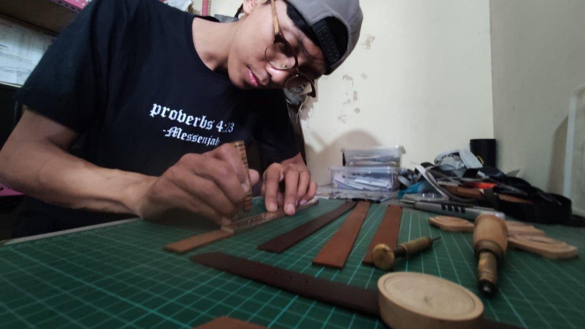Pemilik Loosewood, Andhika Praditya (31) saat mengerjakan limbah kayu bekas papan skateboard di kiosnya yang berada di Lantai 2 Pasar Elpabes, Banjarsari, Solo, Kamis (27/6/2024).