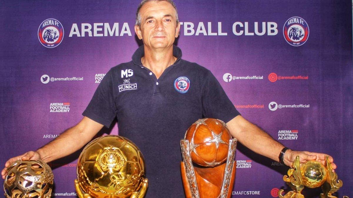 Potret Milomir Seslija bersama dengan tropi kemenangannya selama berada di Arema FC