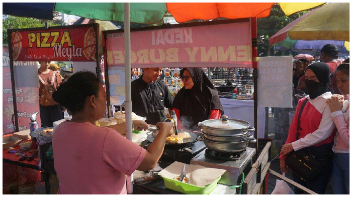 Pembeli Kedai Jenny Burger dan Pizza Meyla sedang mengantre menunggu dilayani saat car free day di Jalan Slamet Riyadi, Solo.