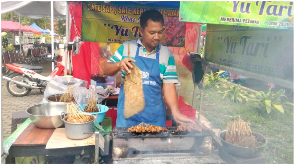MANFAAT PENGGUNAAN QRIS BRI - Pemilik Sate Kere Yu Tari, Hanafi, sedang membakar sate kere yang hendak disajikan pada pembeli di Pasar Takjil Ramadan, Kota Solo, pada Sabtu (22/3/2025).
