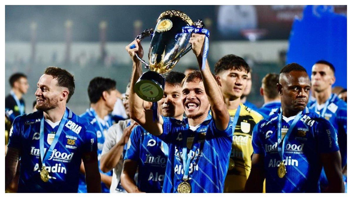 Potret Rezaldi Hehanussa angkat trofi juara Liga 1 Indonesia musim 2023/2024 bersama Persib Bandung.