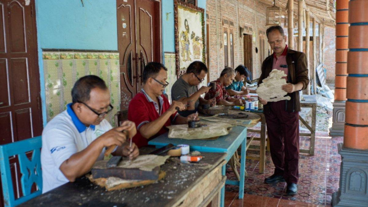 Potret Dalang Wuryanto (berdiri) ketika tengah memilah wayang yang hendak dipesan dari Butuh, Sidowarno, Klaten, Jumat (25/10/2024).