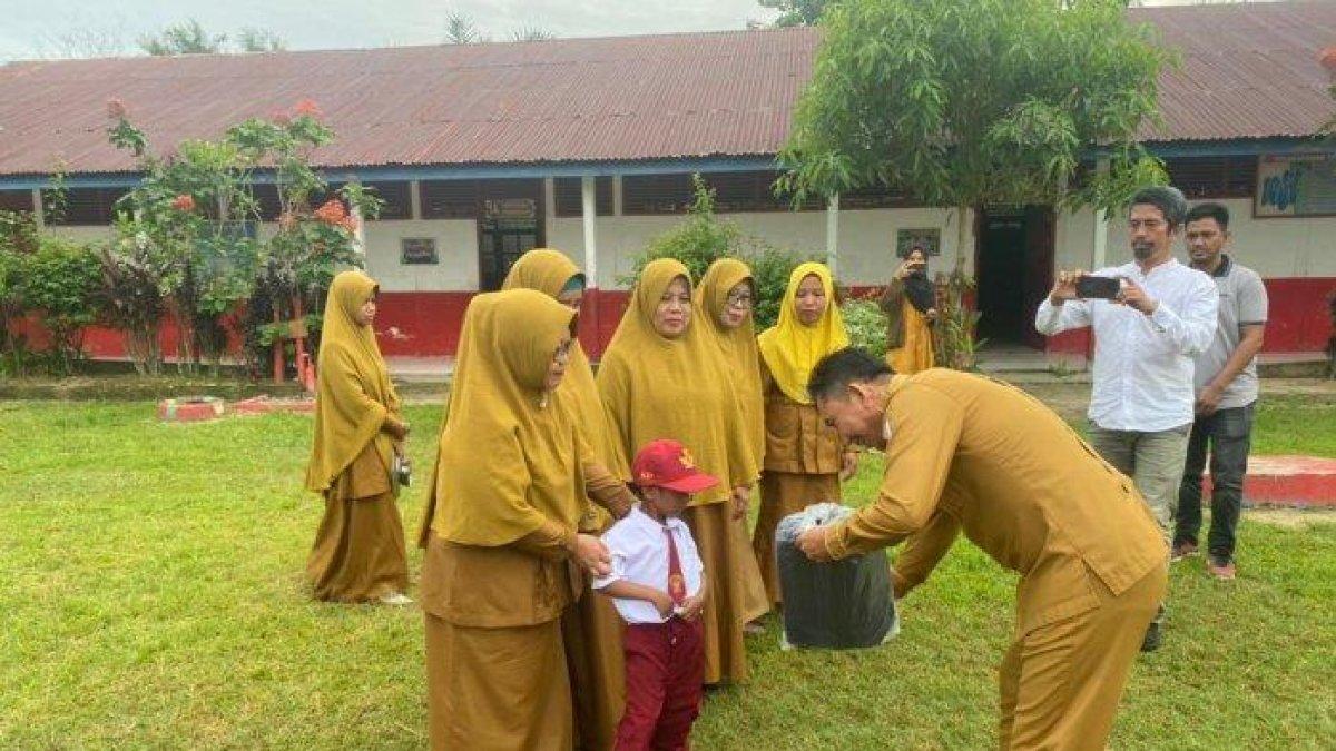 Kepala Dinas Pendidikan dan Kebudayaan Sulbar Mithhar Thala Ali menyerahkan bantuan kepada Muhammad Firdaus di SD Inpres Desa Kuo, Kecamatan Pangale, Kabupaten Mamuju Tengah, Sulawesi Barat, pada Selasa (16/7/2024).