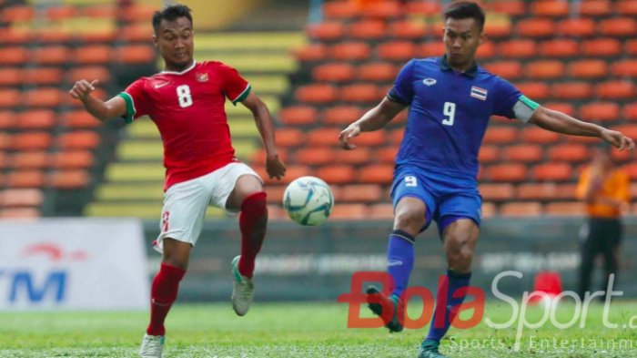 Muhammad Hargianto, berduel memperebutkan bola dengan kapten timnas Thailand.