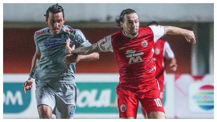 Penyerang Persib Bandung Ezra Walian (kiri) membanyangi gelandang Persija Jakarta Marc Klok (kanan) pada leg pertama final Piala Menpora 2021 di Stadion Maguwoharjo, Sleman, Kamis (22/4/2021).